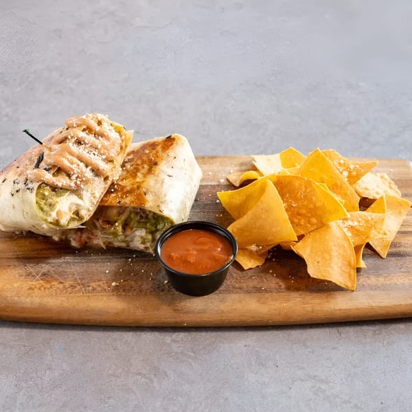 Grilled burrito with sauce and cheese, served with tortilla chips and salsa on a wooden board.